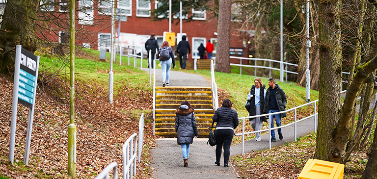 students walking up the hill on campus