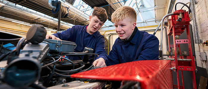 two students working on a car