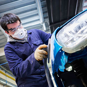 student sanding down vehicle bodywork