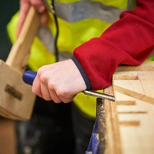 student using chisel on wood