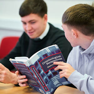 students reading a criminology book