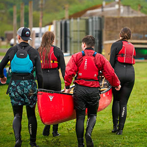 students carry a canoe