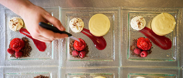 close up of student plating up a dessert