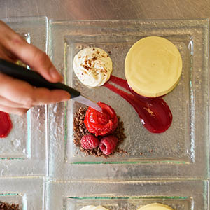 close up of student plating up a dessert