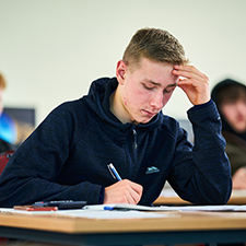 student writing in a classroom