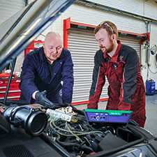 students looking over a car bonnet