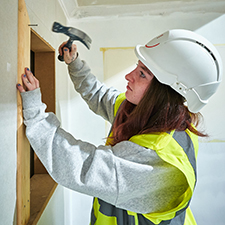 student using a hammer on a door